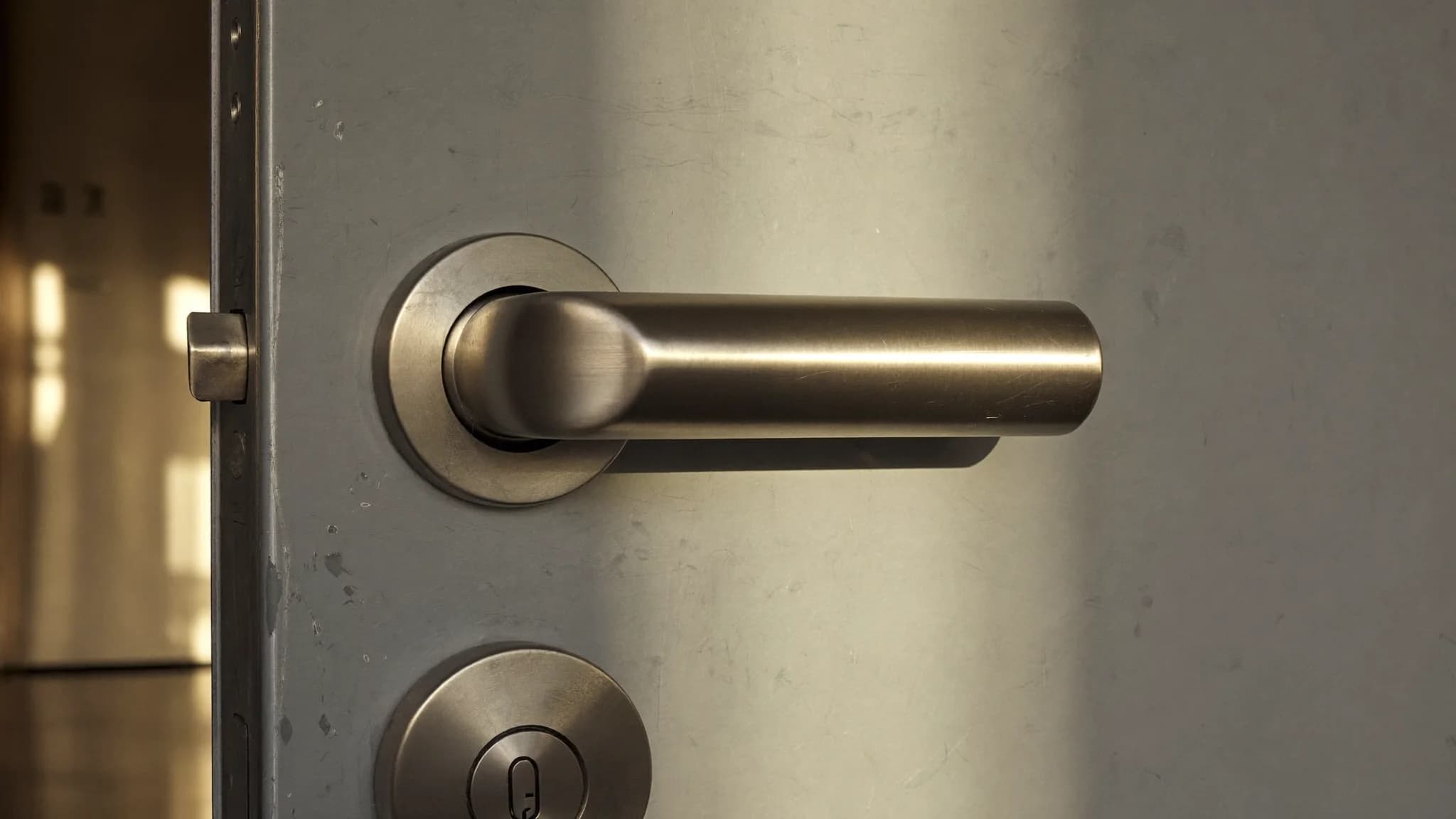 Close-up of a modern apartment door handle and lock in warm afternoon light