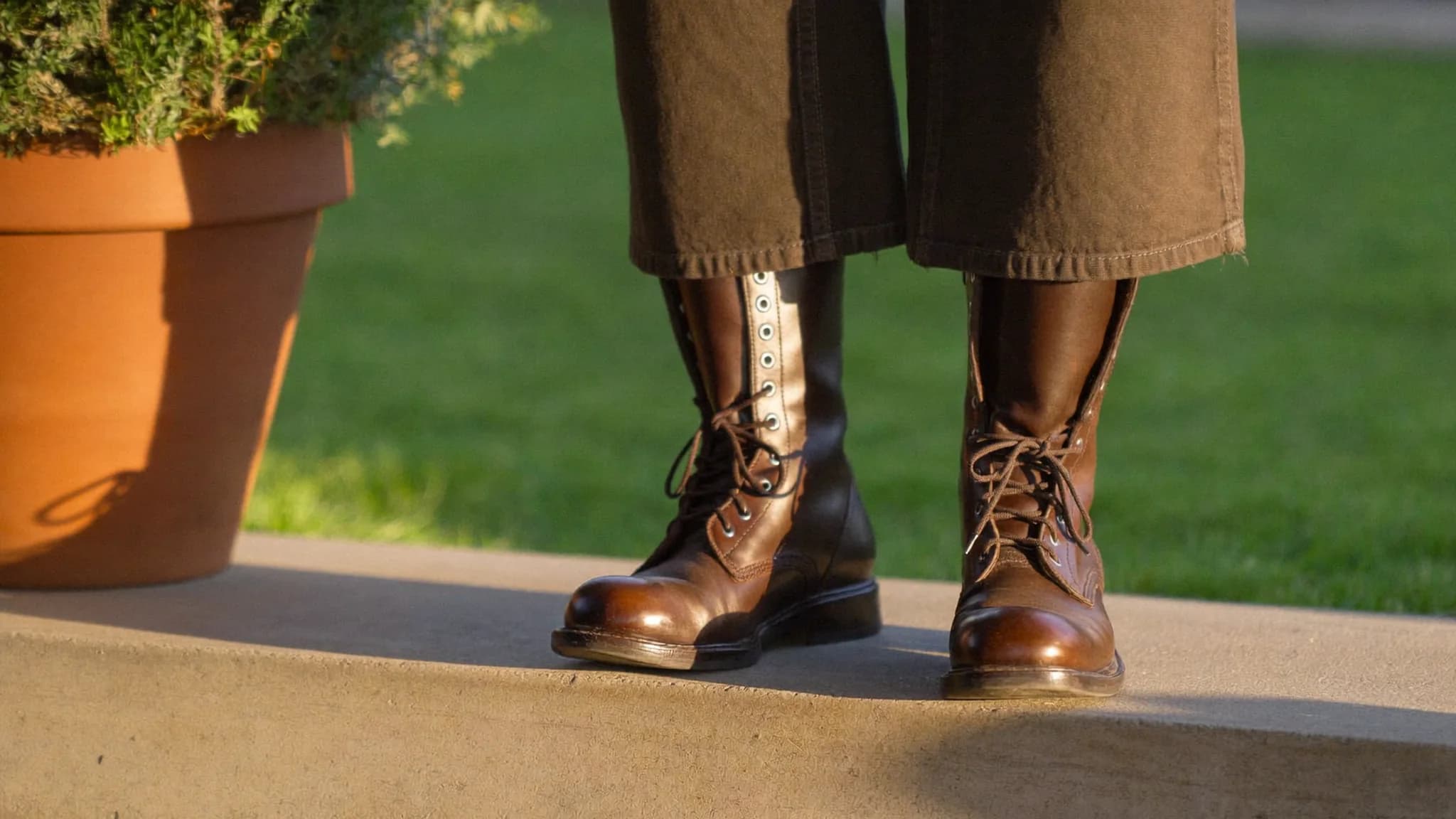 Close-up of a door-to-door sales rep's work boots on a suburban front step in late afternoon light