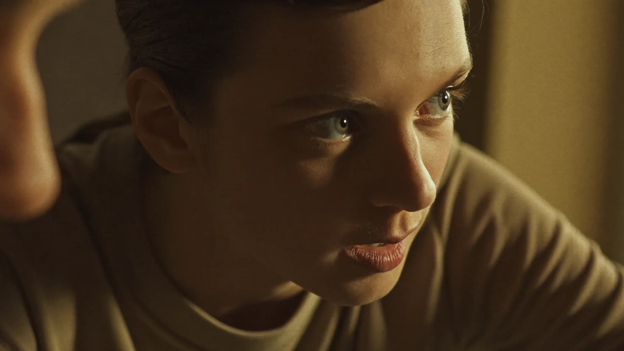 A close-up of a person listening intently during a conversation with an attentive expression in soft window light.