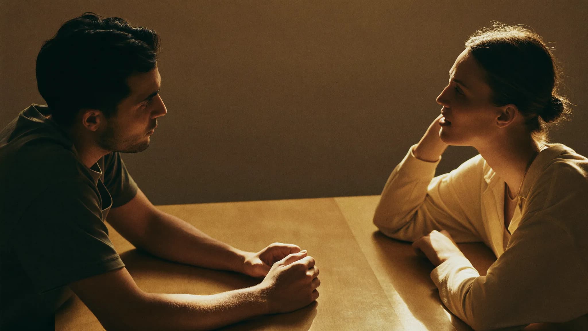 Two people at a table in warm window light, one nodding in agreement, reaching a yes.